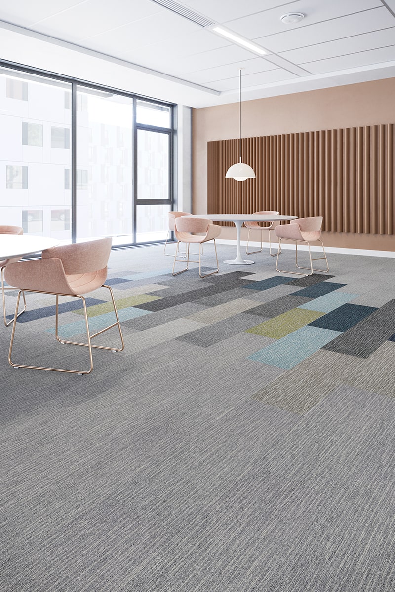 Alfombra modular gris con acentos de color en sala de juntas